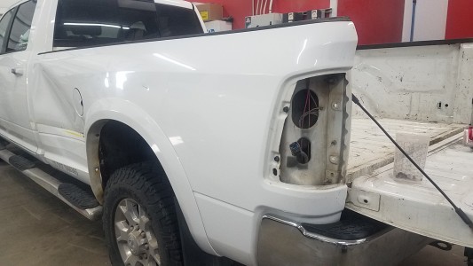 White Sierra pickup truck dented from collision