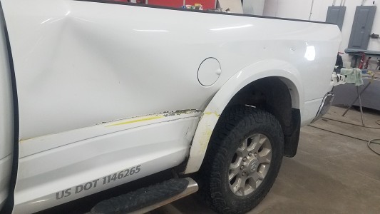 White Sierra pickup truck dented from collision