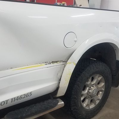 White Sierra pickup truck dented from collision