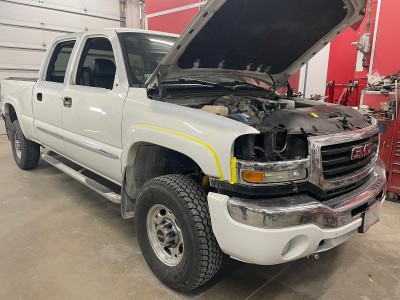 In-progress collision repairs on white Sierra pickup truck