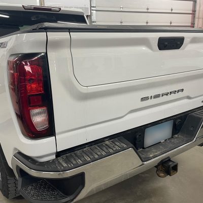 Repaired tailgate of white Sierra pickup truck