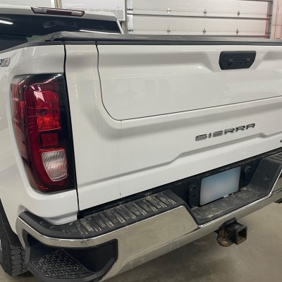 Repaired tailgate of white Sierra pickup truck