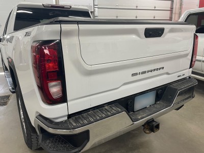 Repaired tailgate of white Sierra pickup truck